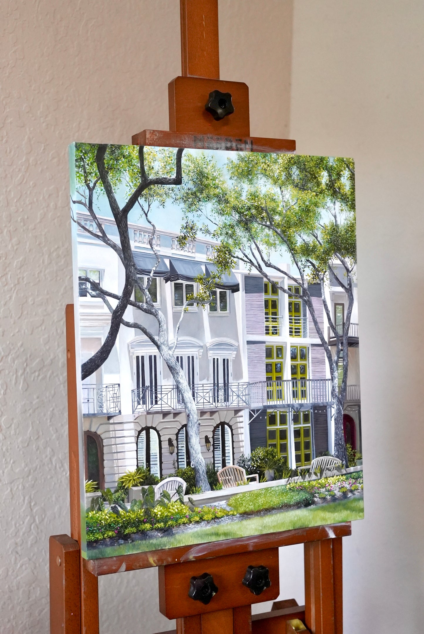 Painting of a garden scene on an easel against a white wall