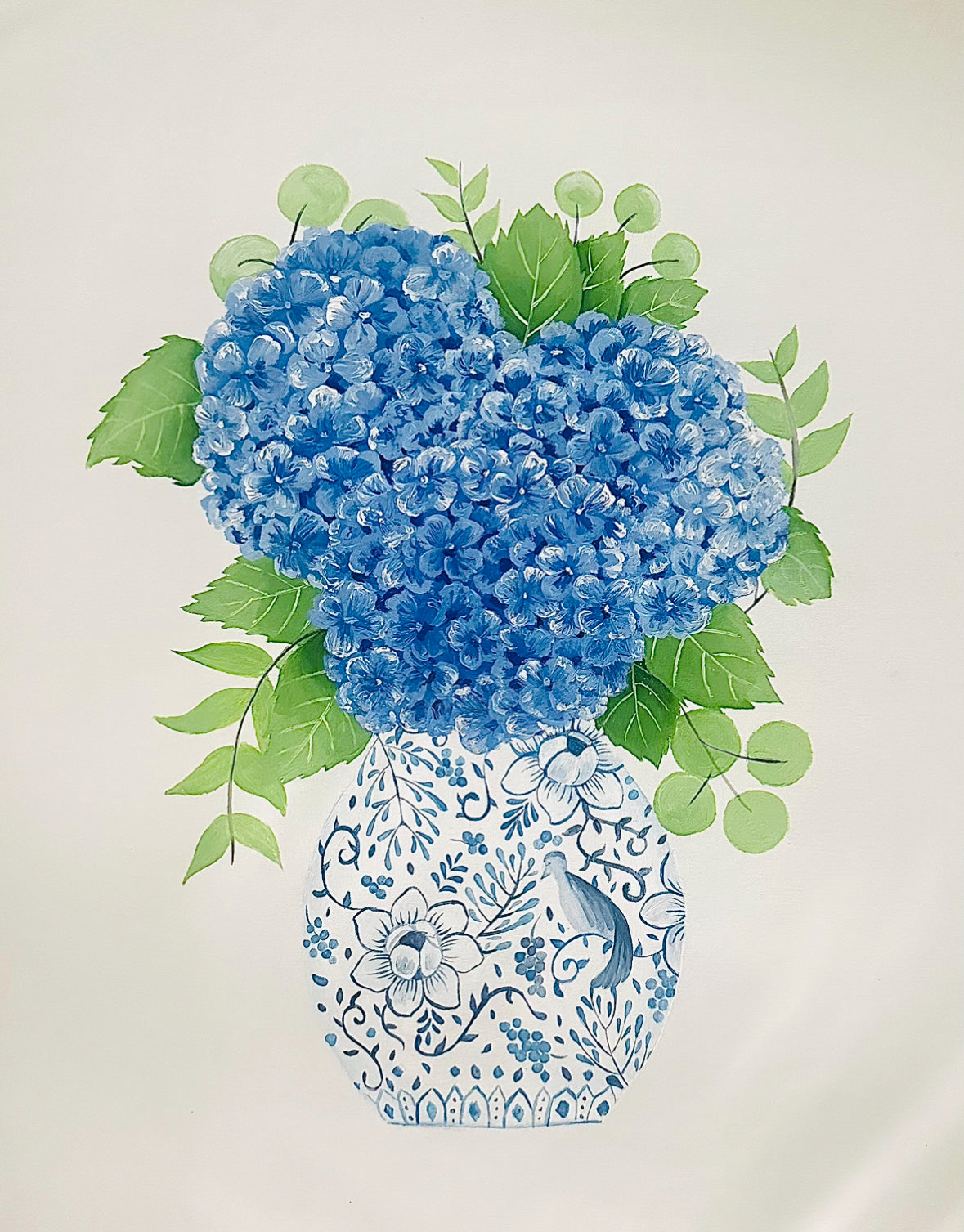 Blue flowers in a decorative vase with green leaves on a light background