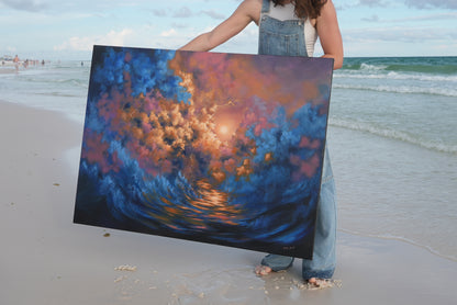 Avery holding a large abstract painting on a beach