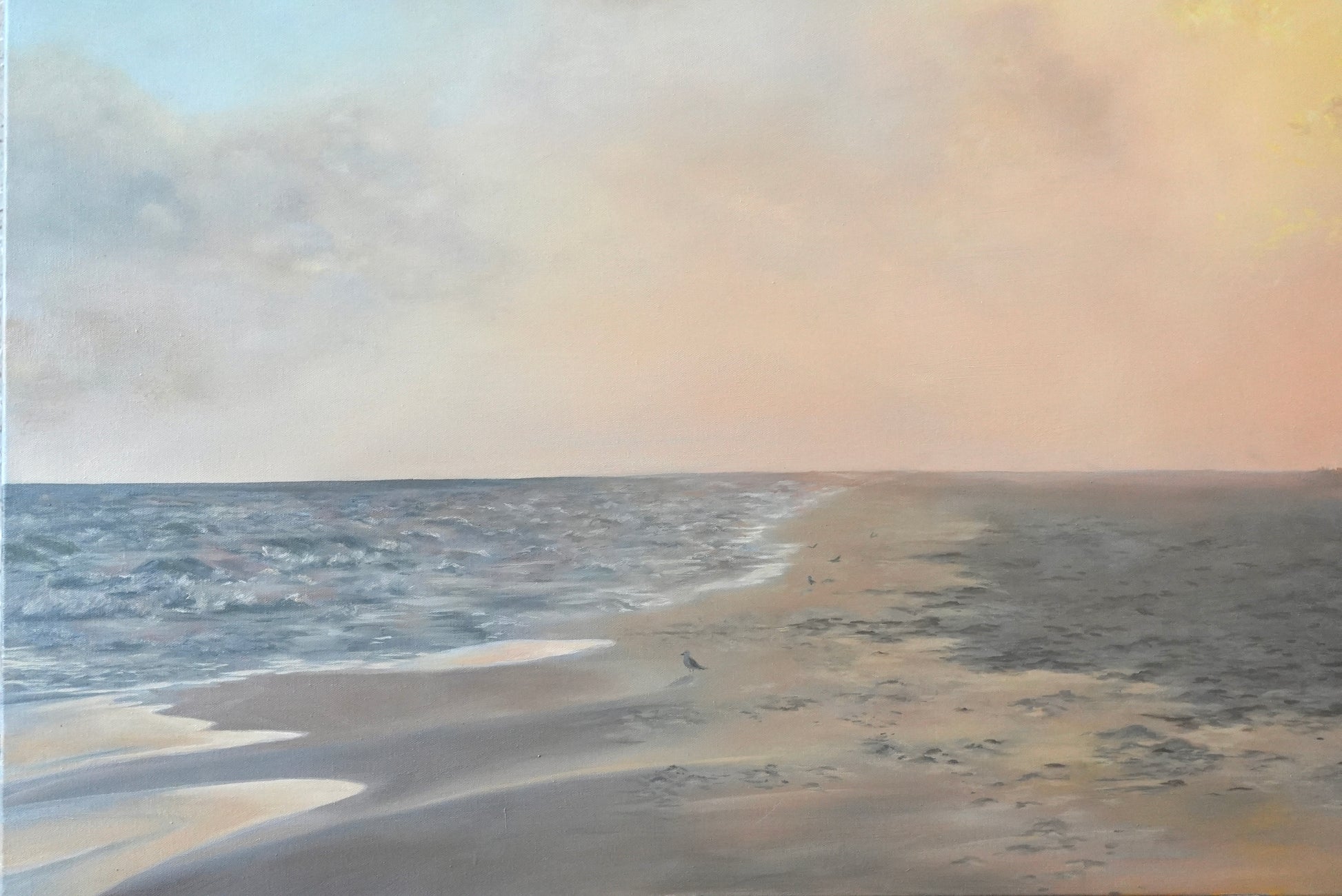 Beach scene with sand and water under a cloudy sky