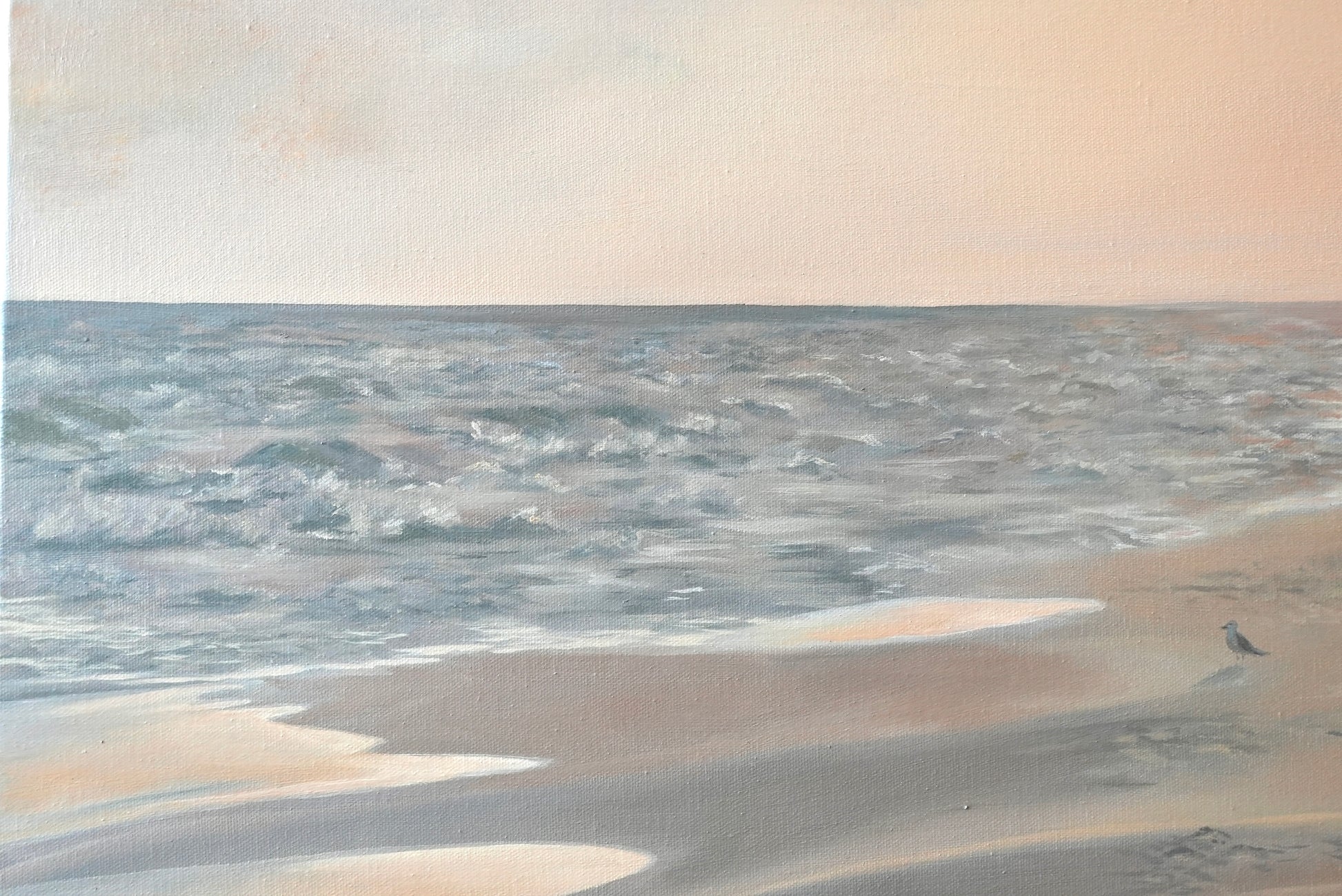 Beach scene with sand and water under a cloudy sky