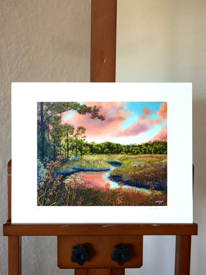 Painting of a landscape with trees and a sky on an easel.