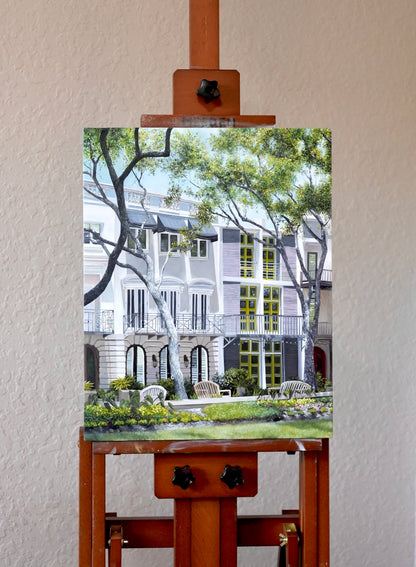 Painting of a courtyard scene on an easel against a white wall